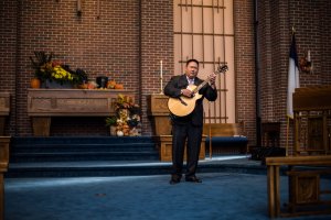 Pastor Eric Song playing his guitar during the groomsmen entrance.